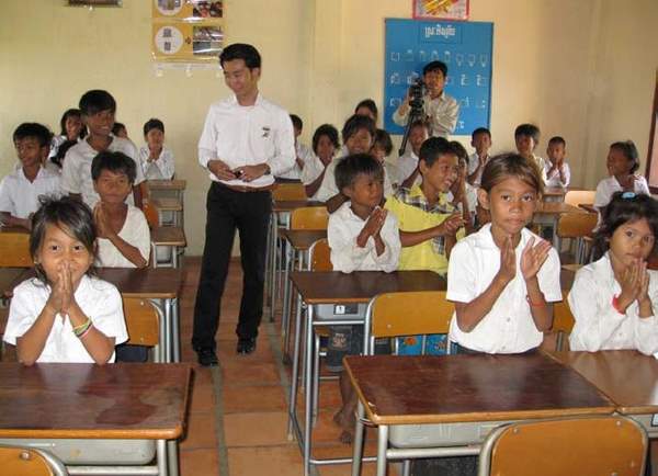 寄贈した机・イスを利用する小学生